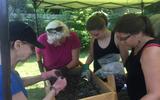 A group of volunteers screening through soil 