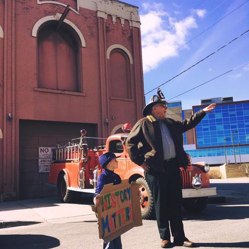 Saint Paul historian Jim Sazevich and young helper address in 2016 a community gathering to protest the threatened demolition of Hope Engine Co. No. 3, the city's oldest municipal building, constructed in 1872. 